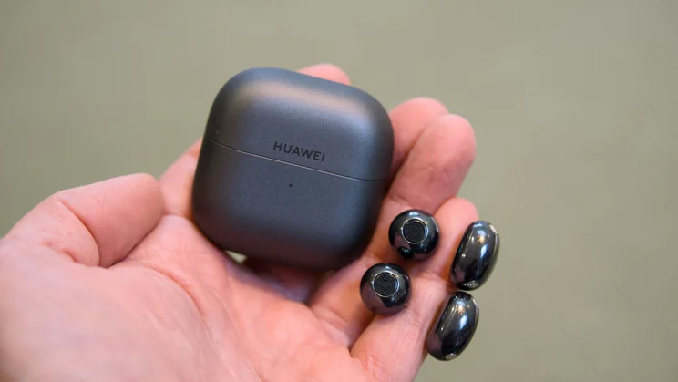 The Huawei FreeClip 2 and charging case held in hand