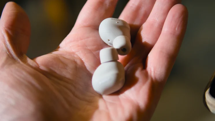 The Sony WF-1000XM6, pictured being held in an open hand