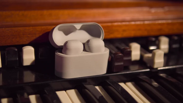 The Sony WF-1000XM6 pictured on a music keybaord in their charging case