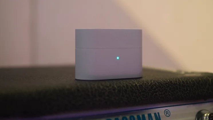 The Sony WF-1000XM6's charging case on top of a guitar amplifier