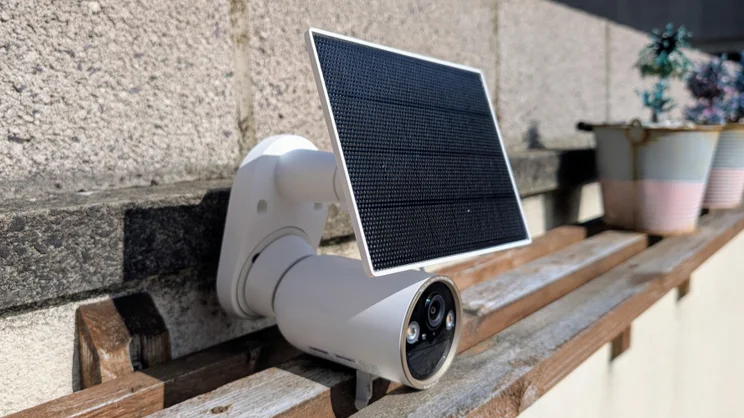 The Tapo C460 security camera pictured set on a wood shelf from the left side
