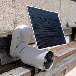 The Tapo C460 security camera pictured set on a wood shelf from the left side