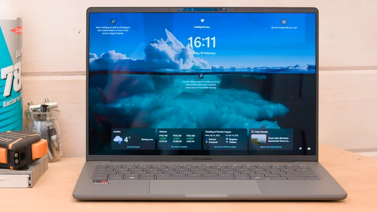 The Asus Zenbook A14 pictured from the front on a wood workbench