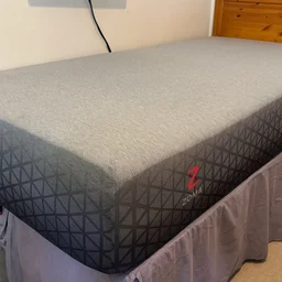 The Zoma Hybrid mattress pictured on a single bed frame