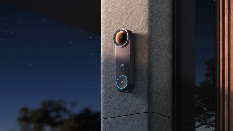 The Eufy Video Doorbell S4, at night, mounted on a white rendered wall next to a dark wood door, modern architecture
