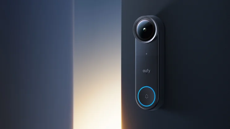 A close up of the Eufy Video Doorbell S4, at night, mounted on a white rendered wall next to a dark wood door, modern architecture