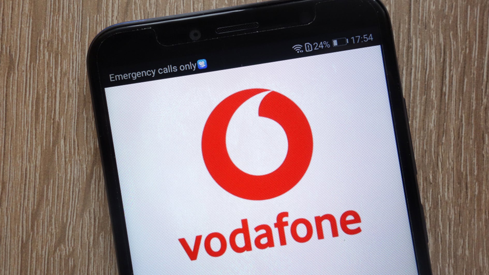 vodafone logo on mobile screen with wood background