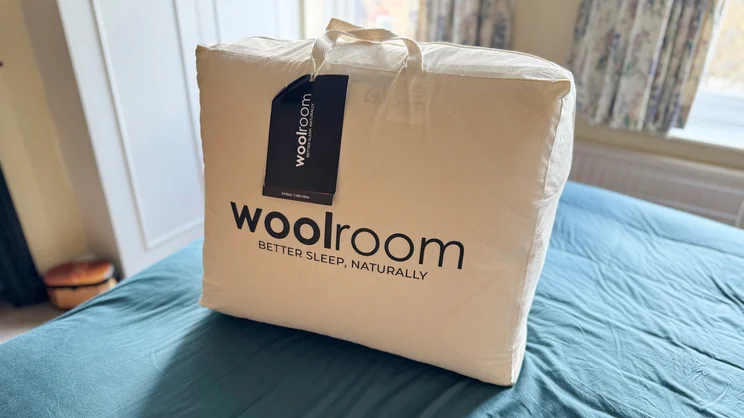 The Woolroom Deluxe Washable 3-in-1 Wool duvet in its bag on a bed