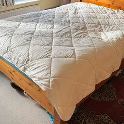 The Woolroom Deluxe Washable 3-in-1 Wool duvet on a bed in a bedroom