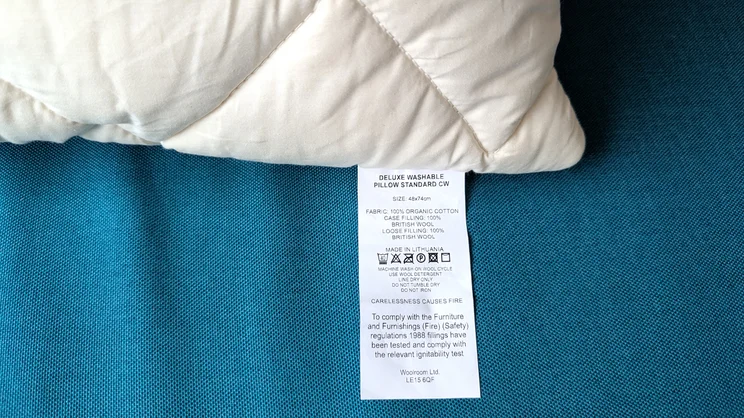 A close up of the Woolroom Deluxe Washable Wool Pillow's care label