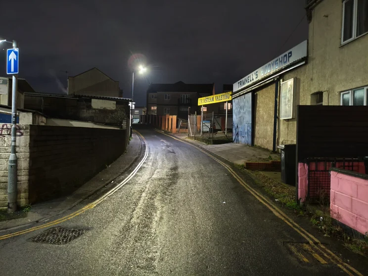A quiet street at night, lit by a lamppost