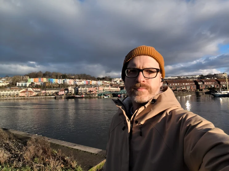 Selfie of author Jon Mundy in front of a river on a cloudy day