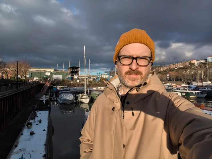 Selfie of author Jon Mundy in front of a harbour full of boats