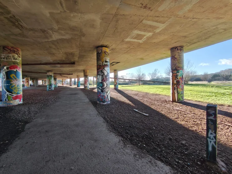 Ultrawide shot of the graffiti-covered columns holding up a bridge