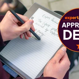 A photo of the Amazon Kindle Scribe 2022 being used with an Expert Reviews Approved Deal stamp in the top right corner